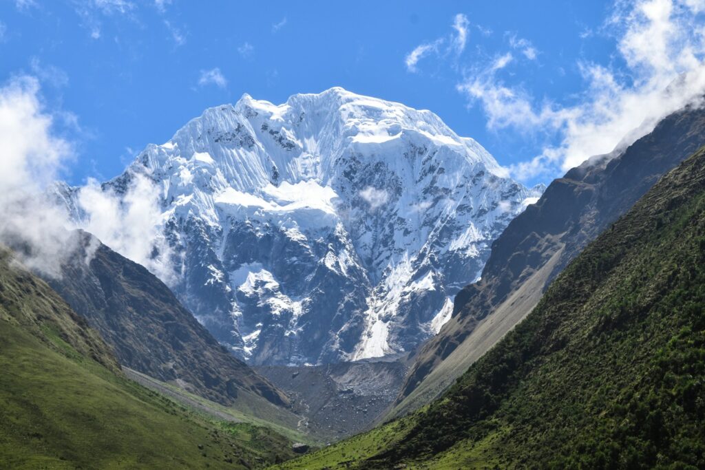 a snow covered mountain in the middle of a valley