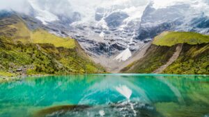 body of water with green mountains during daytime